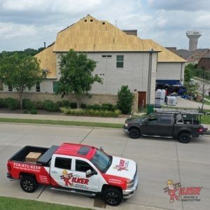 Two trucks are parked in front of a house that is under construction.