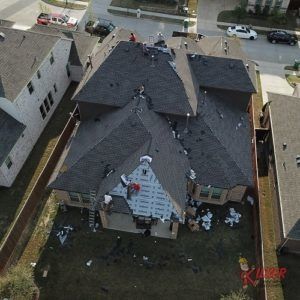 An aerial view of a house with a new roof being installed.