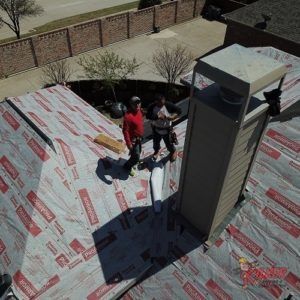 An aerial view of a roof with a chimney being installed.