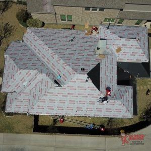 An aerial view of a roof being installed on a house.