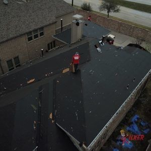 An aerial view of a roof with a man standing on it.