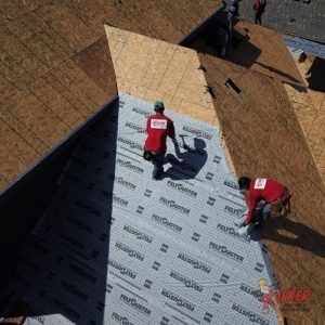 A group of men are working on a roof.