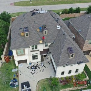 An aerial view of a house with a roof being repaired.