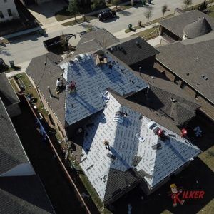 An aerial view of a roof being installed on a house.