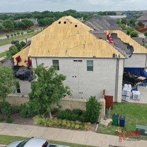An aerial view of a house with a new roof being installed.