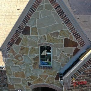 A brick building with a stone facade and a window