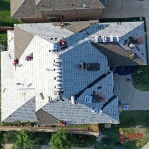 An aerial view of a house with a new roof being installed.