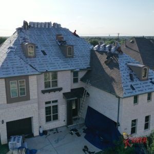 An aerial view of a house with a roof being installed.