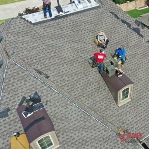 An aerial view of a group of people working on a roof.