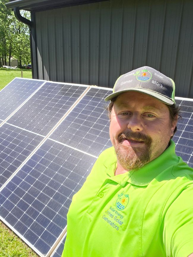 A worker in a yellow hard hat and safety vest installs or inspects black solar panels on a rooftop.