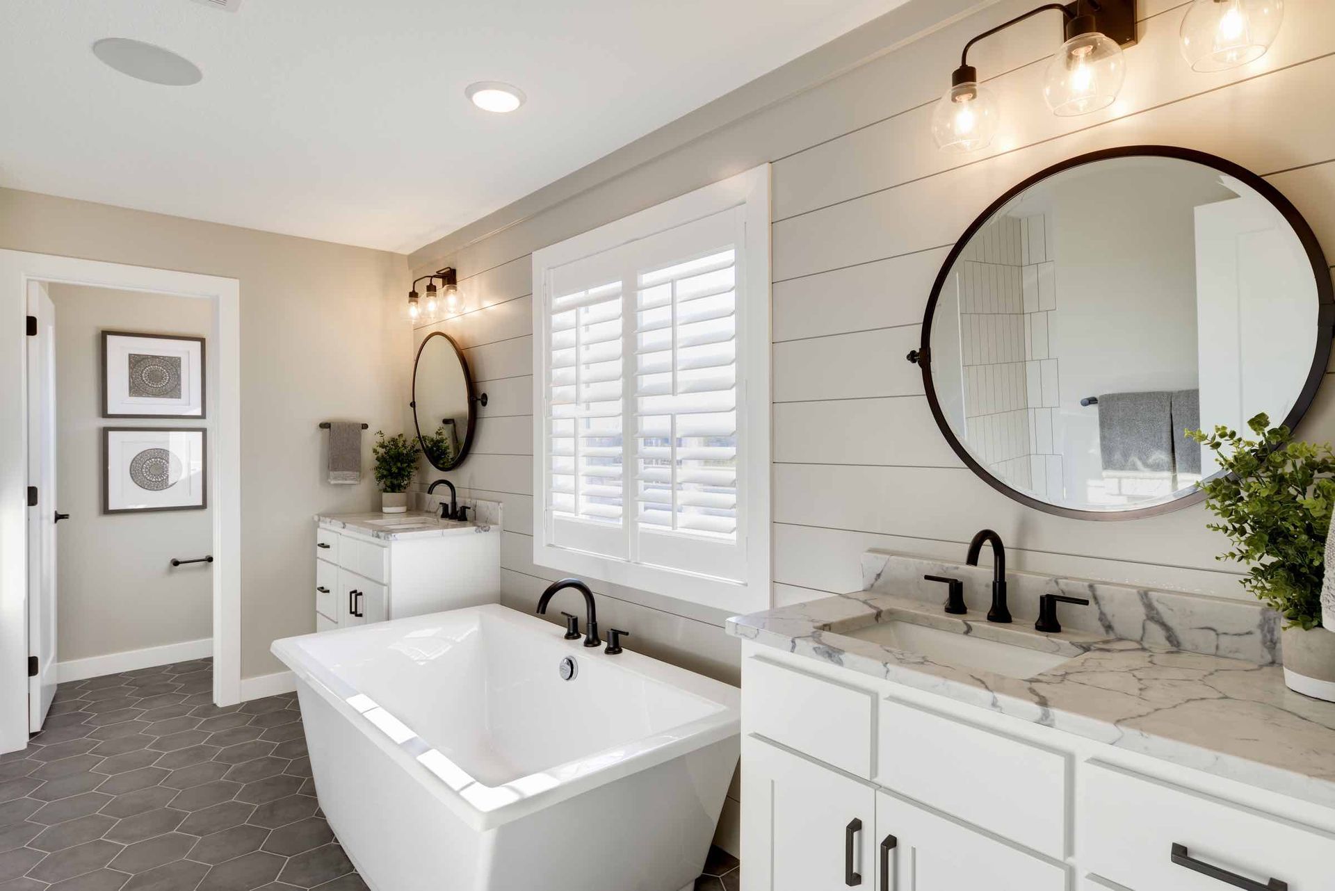 A bathroom with a tub , sink and mirror.