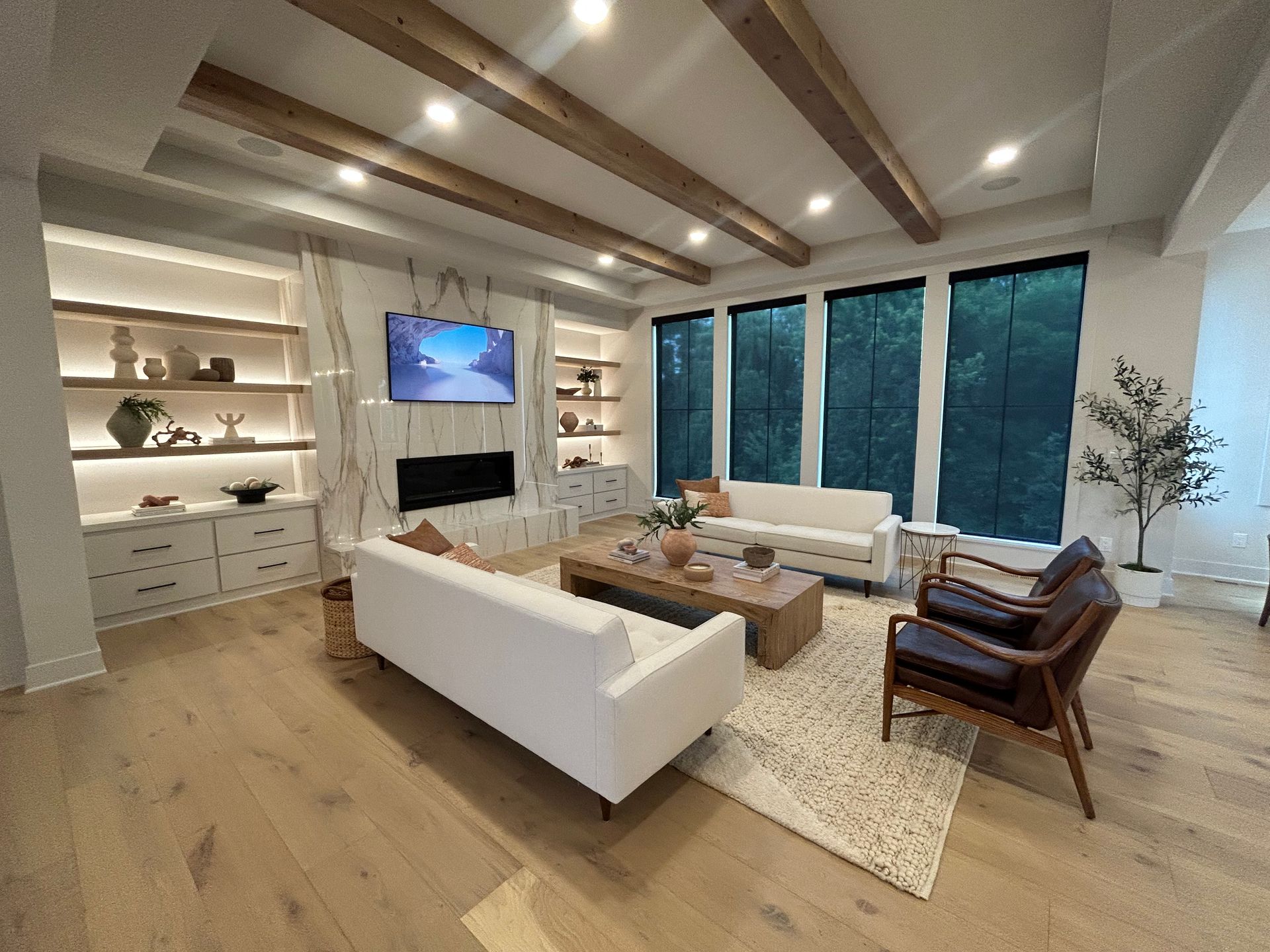 A kitchen with solar shades, a large island , sink , and lots of windows.