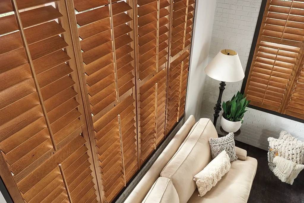 A close-up image of stunning Graber® Wood Shutters on windows in a chic living room