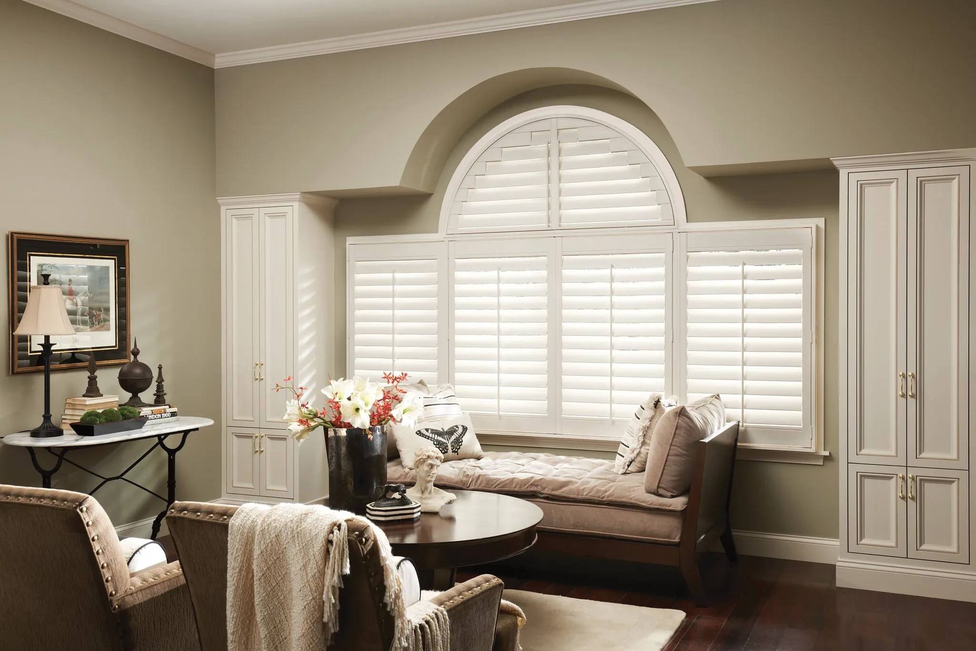 Alta Window Fashion shutters on rectangular and arched windows in a home's sitting area