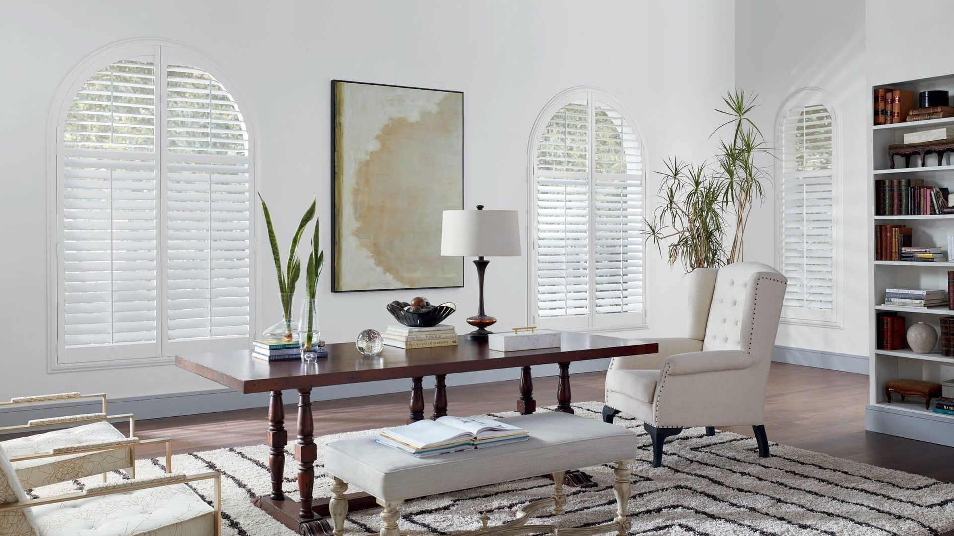 Hunter Douglas NewStyle® Composite Shutters in home office with desk and bookshelf