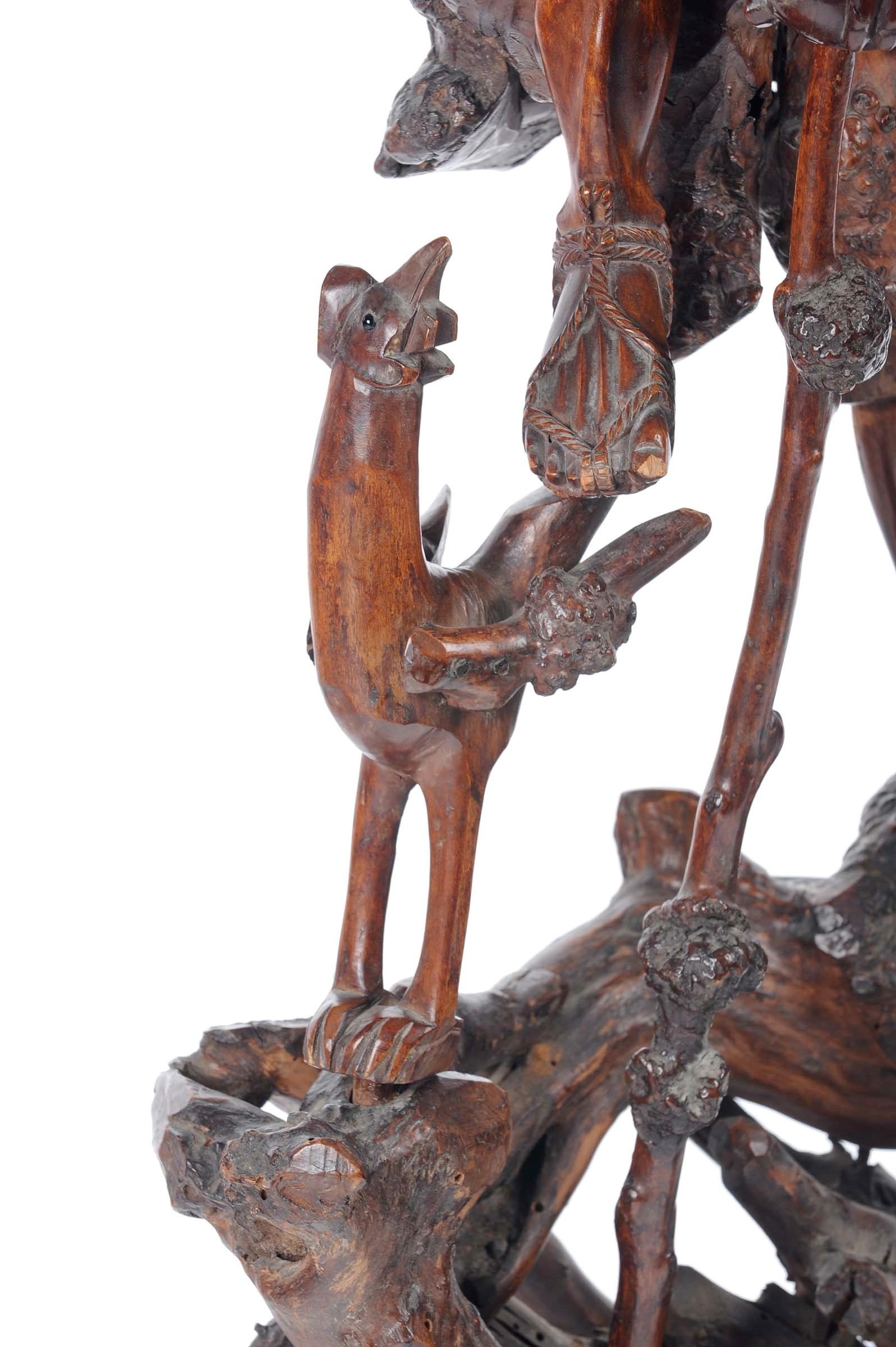 Dettaglio di una scultura in legno intagliato raffigurante personaggio orientale con gallina