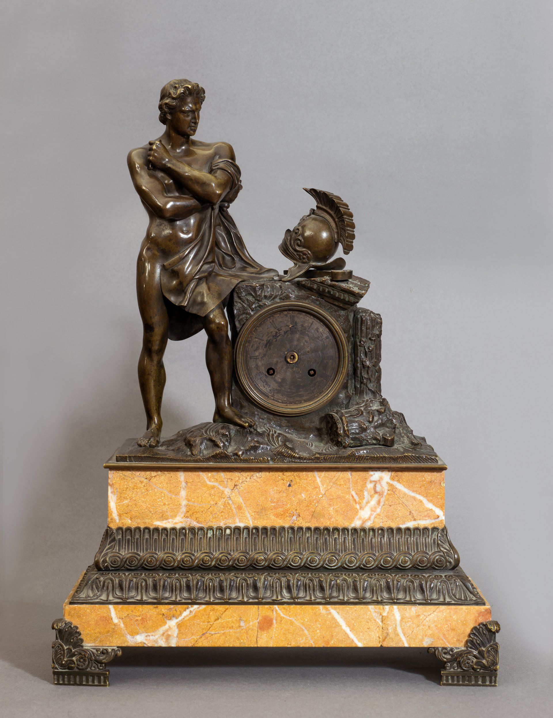 Orologio in bronzo brunito raffigurante Achille con elmo, base in marmo giallo reale secolo XIX