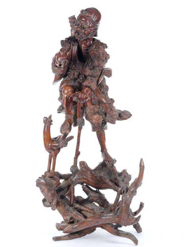 Scultura in legno intagliato raffigurante personaggio orientale con gallina