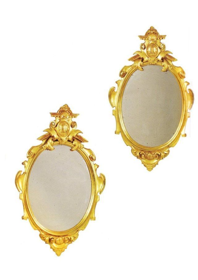 Coppia di ovali in legno dorato con cornice sagomata a volute