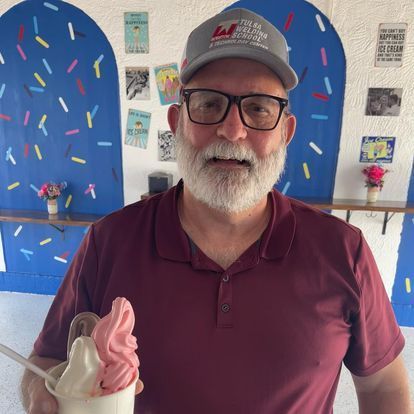 A man wearing a hat that says it 's all about ice cream