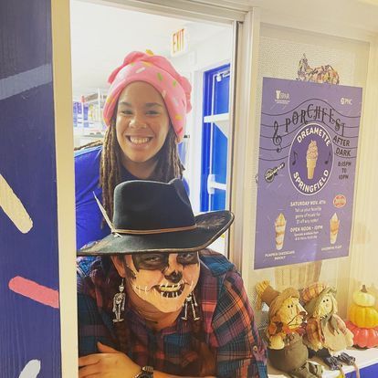 A woman in a cowboy hat is standing next to another woman in a plaid shirt.