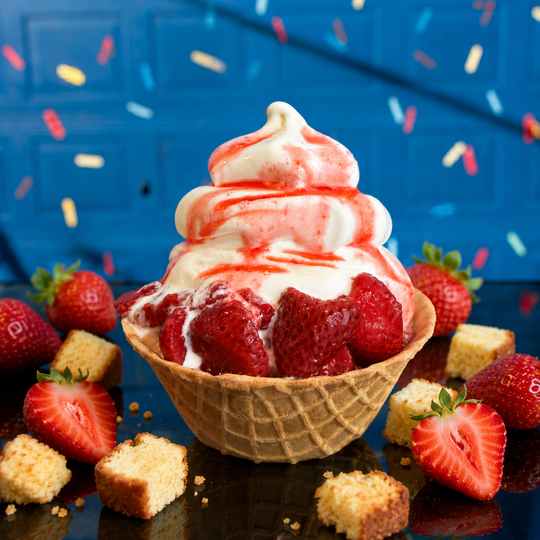 a waffle bowl filled with ice cream and strawberries