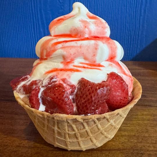a waffle bowl filled with ice cream and strawberries