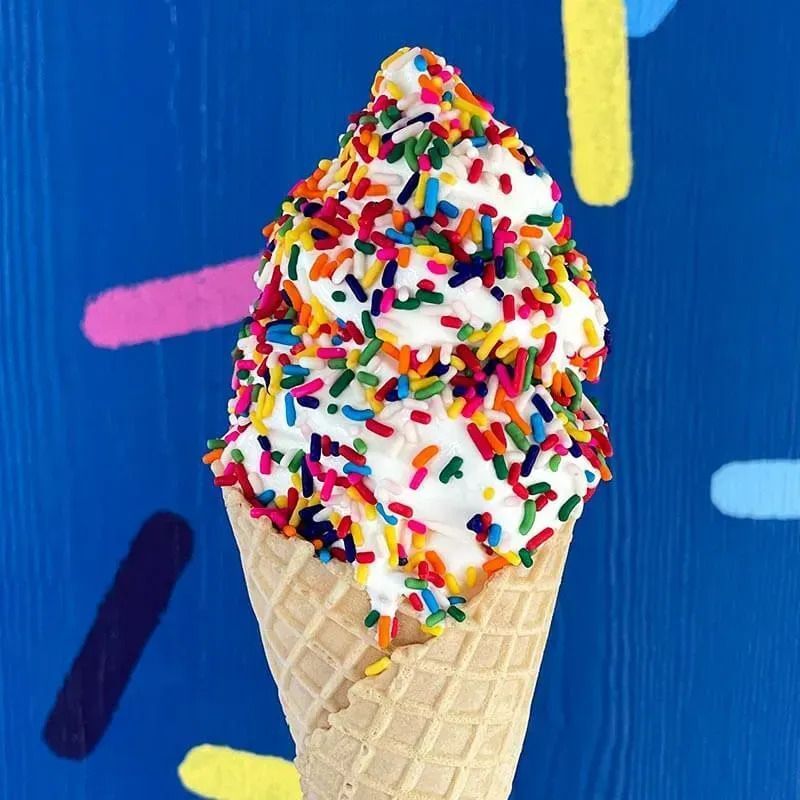 A waffle cone filled with ice cream and sprinkles