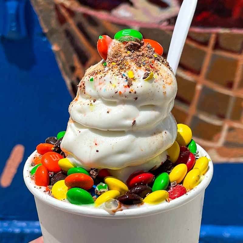A cup of ice cream with m & m 's on top