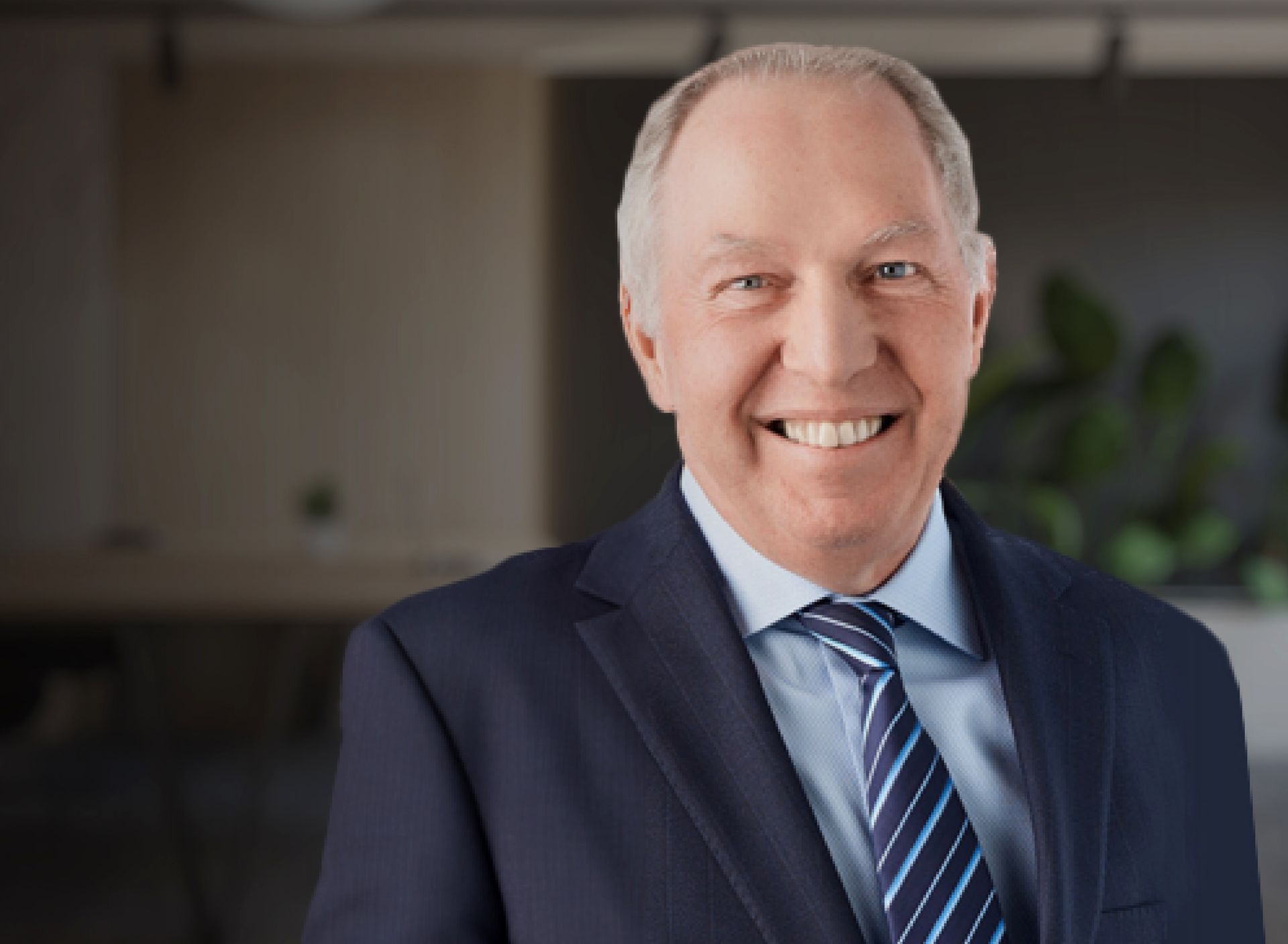 A man in a suit and tie is smiling for the camera.