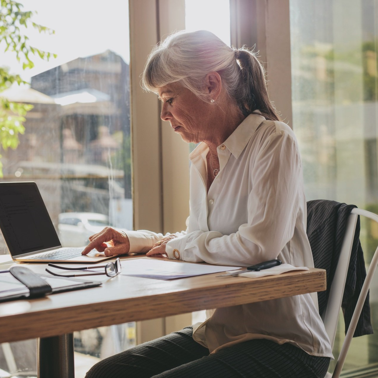 A woman is sitting at a table using a laptop computer.