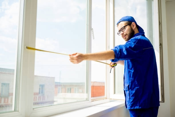 Man in blue uniform stands with a stick, completing residential glass repair by Ken Caryl Glass, Inc