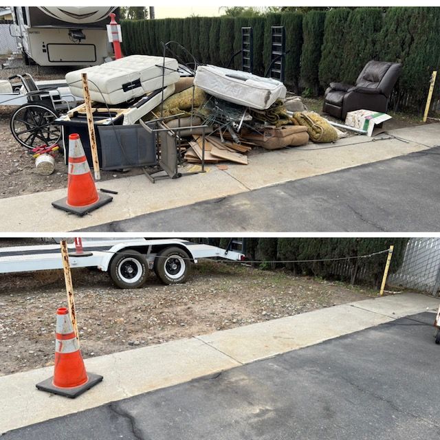 A black dumpster overflowing with construction debris, including wood and cardboard, outdoors.