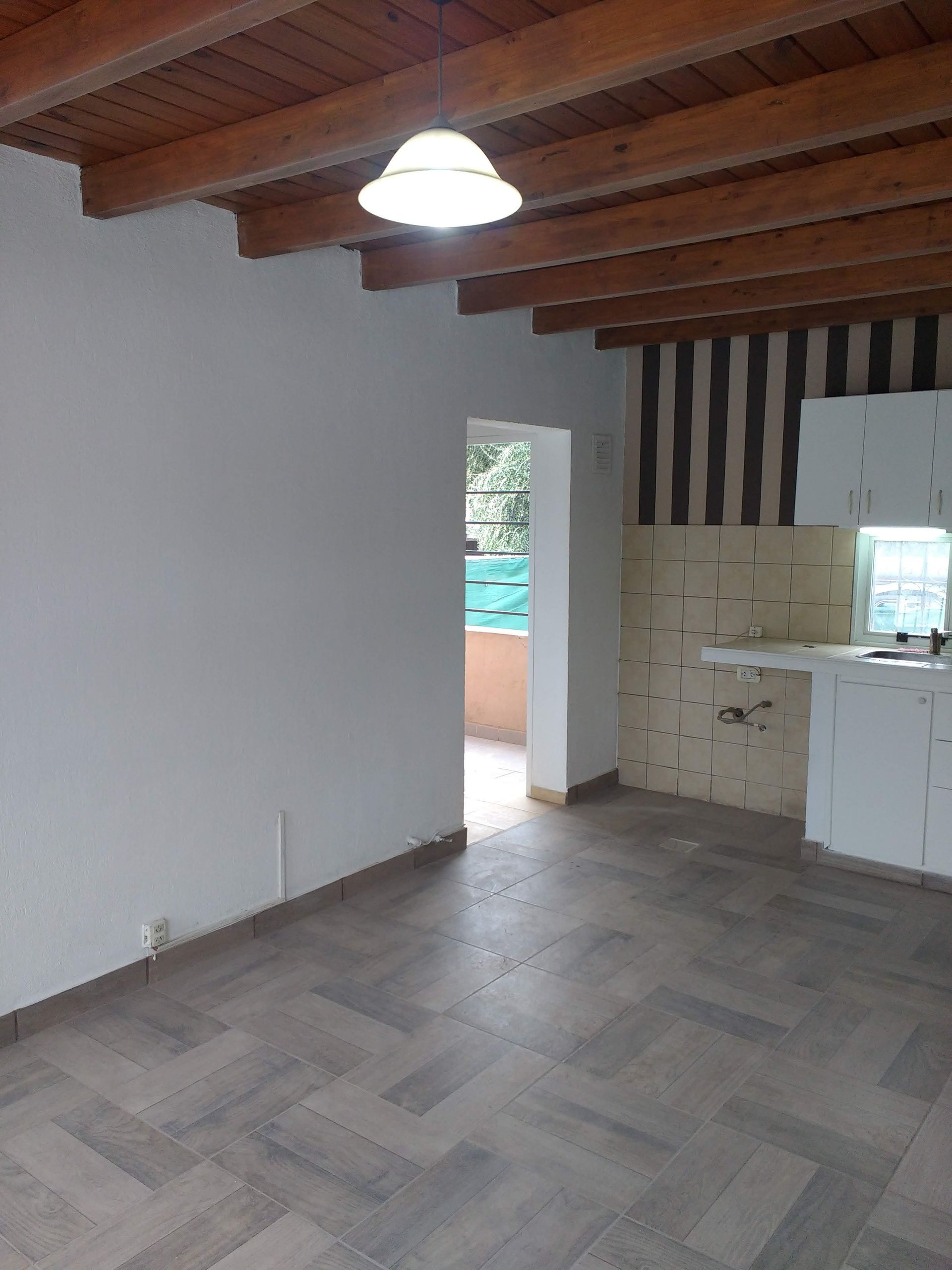 Vista interior de una habitación con vigas de madera en el techo