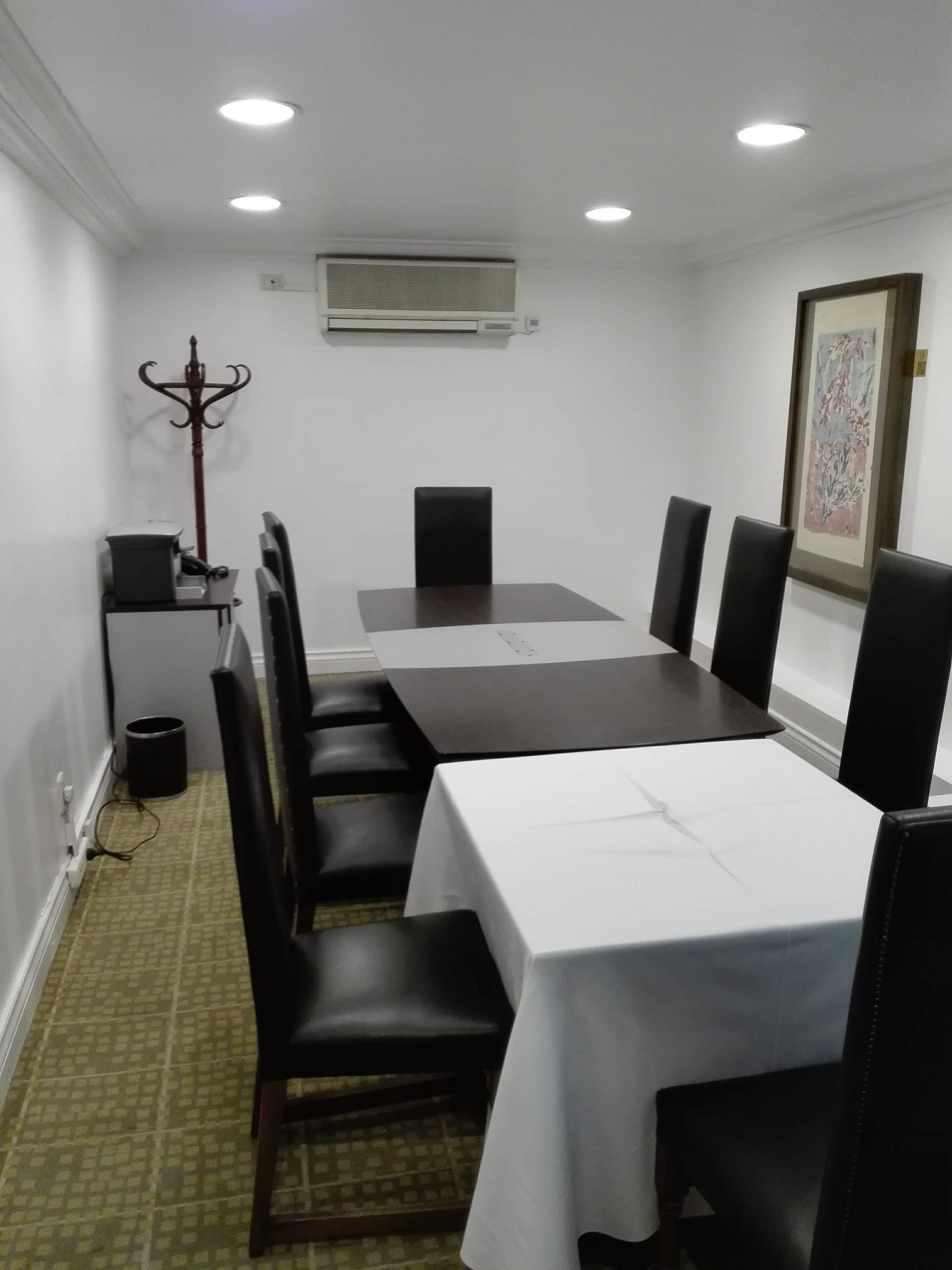 Una sala de conferencias con una mesa larga, sillas y obras de arte en la pared.