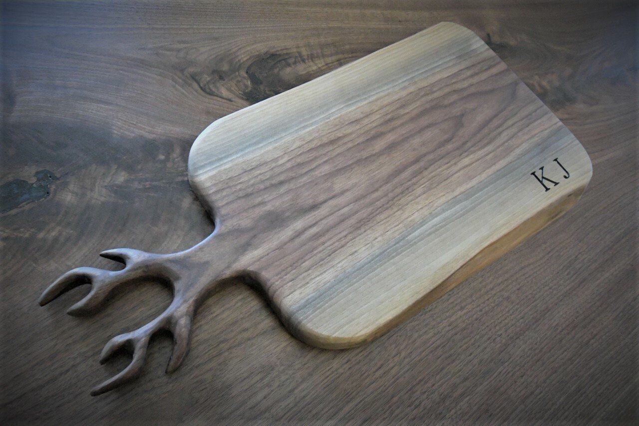 Walnut serving board with antlers and engraving.