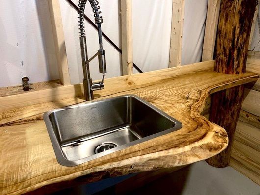 Live edge vanity top for a stainless steel laundry sink.