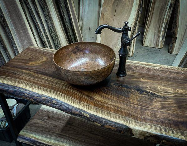 Live edge bathroom vanity with copper vessel sink installed