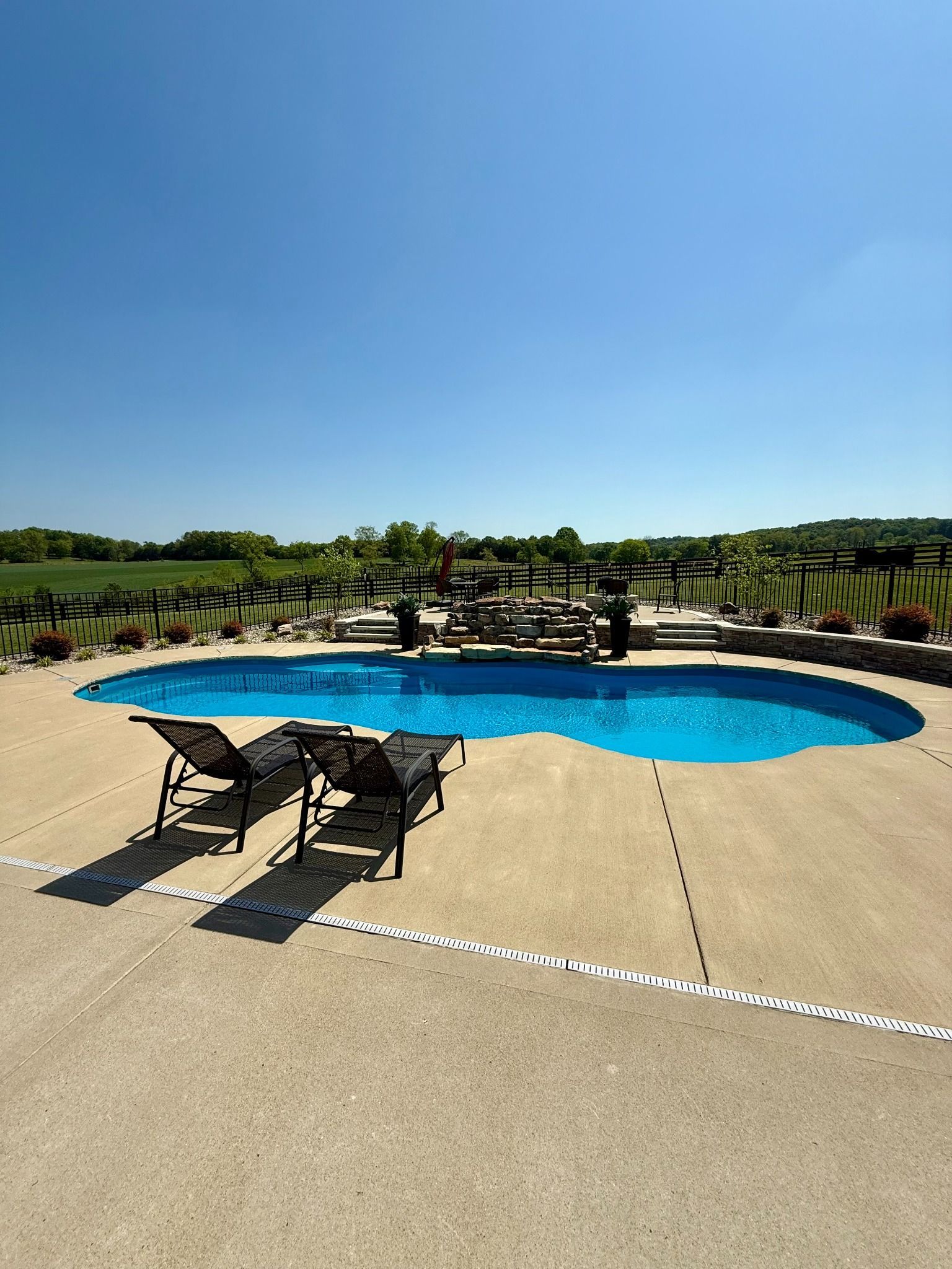 Two lounge chairs beside the 16x40 Lascassas pool with clear blue water
