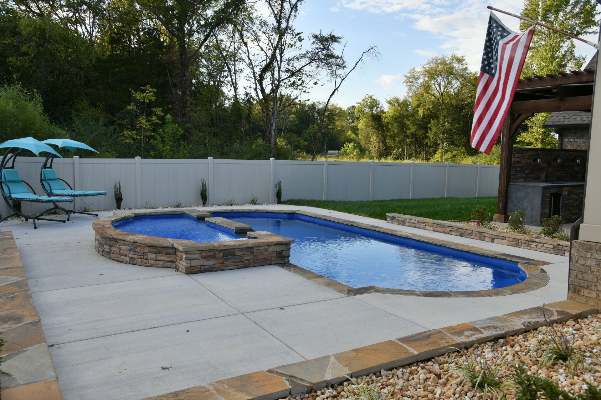 A large swimming pool is in the backyard of a house.