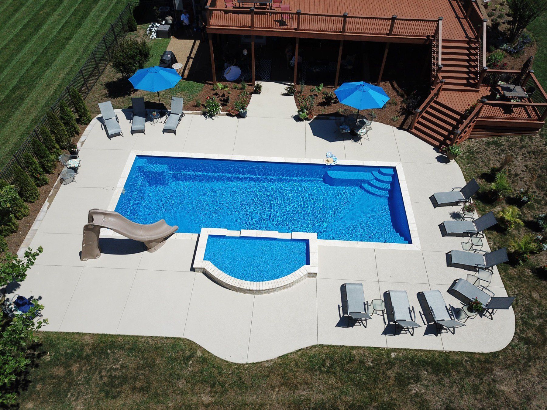 An aerial view of a large swimming pool surrounded by chairs and umbrellas.