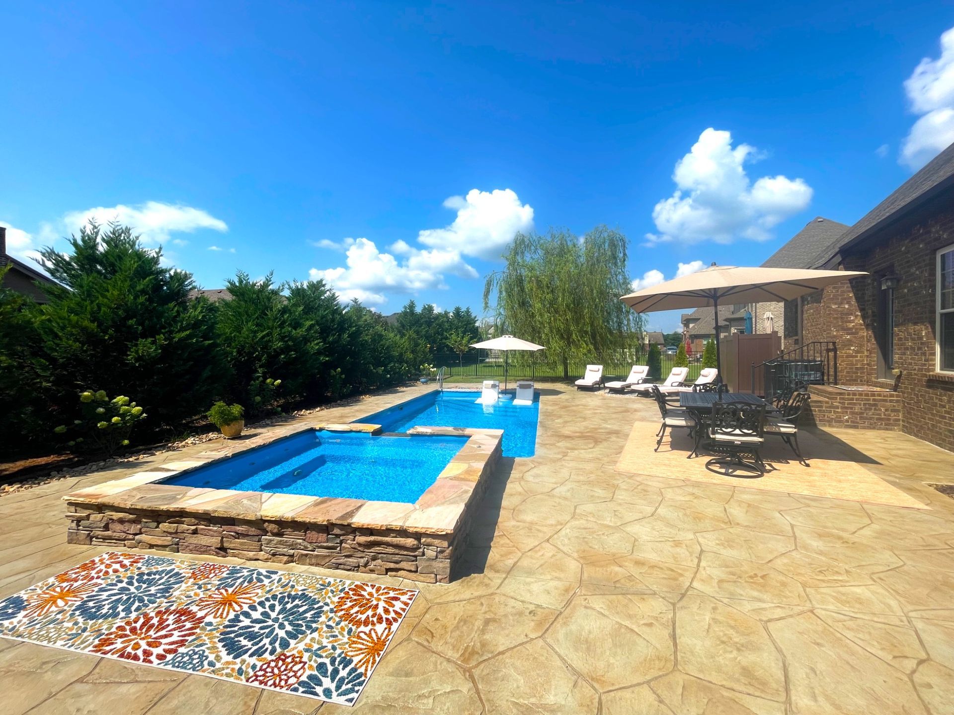 Overview of Aspen 14x30 pool with 9ft spillover spa and stamped concrete patio in Murfreesboro TN