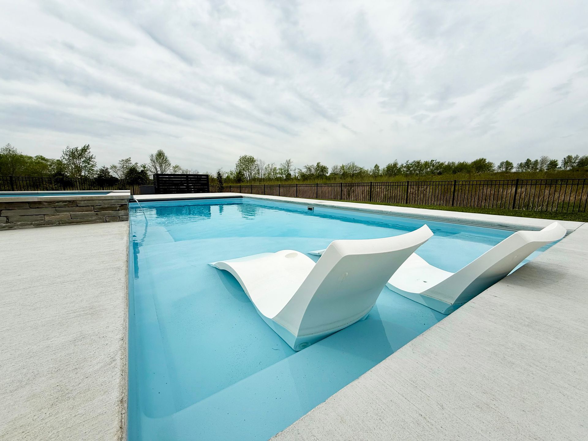Shallow end of Aspen 16x35 fiberglass pool with in-pool loungers in Murfreesboro, TN