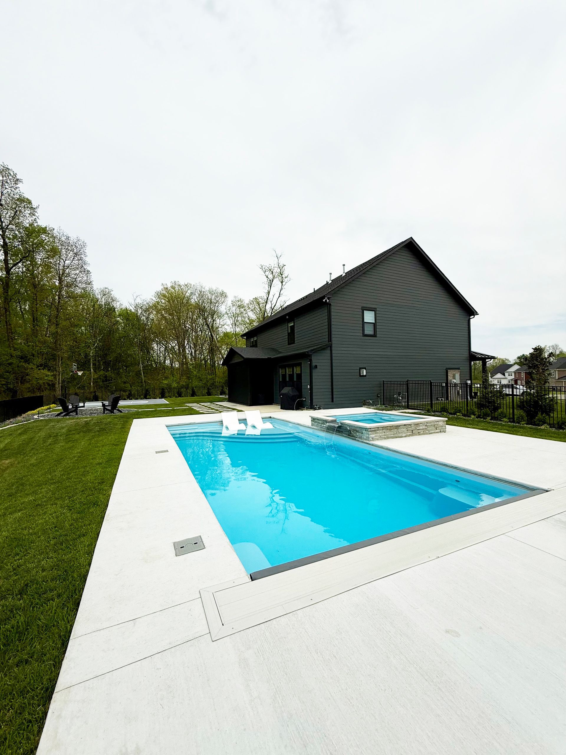 Wide tanning ledge with loungers in an Aspen 16x35 fiberglass pool in Murfreesboro, TN.