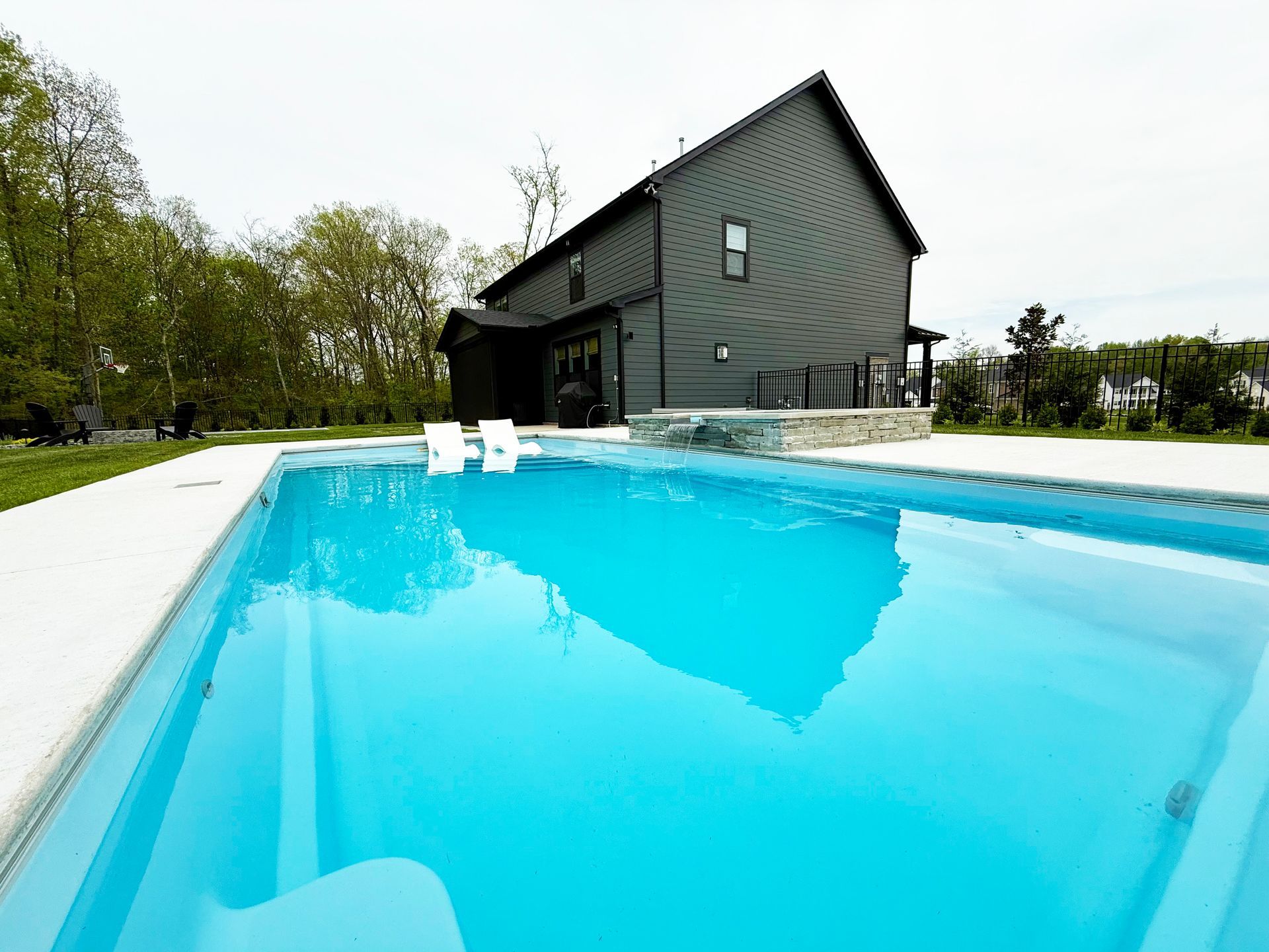 Custom pool design featuring an Aspen fiberglass pool and a spillover spa in Murfreesboro.