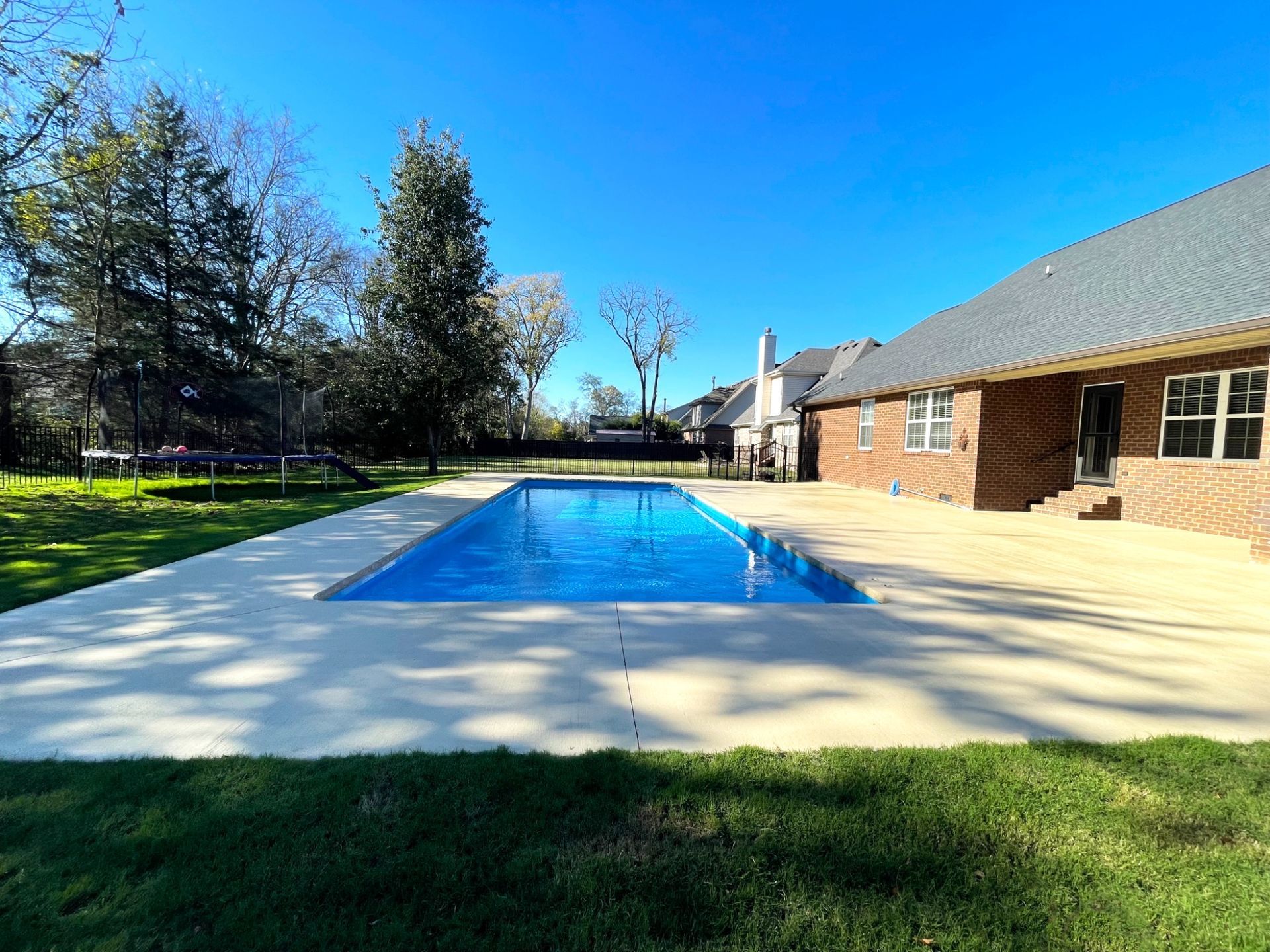 Wide-angle view of a 16x40 Aspen inground pool in Smyrna, TN with lush backyard landscaping.