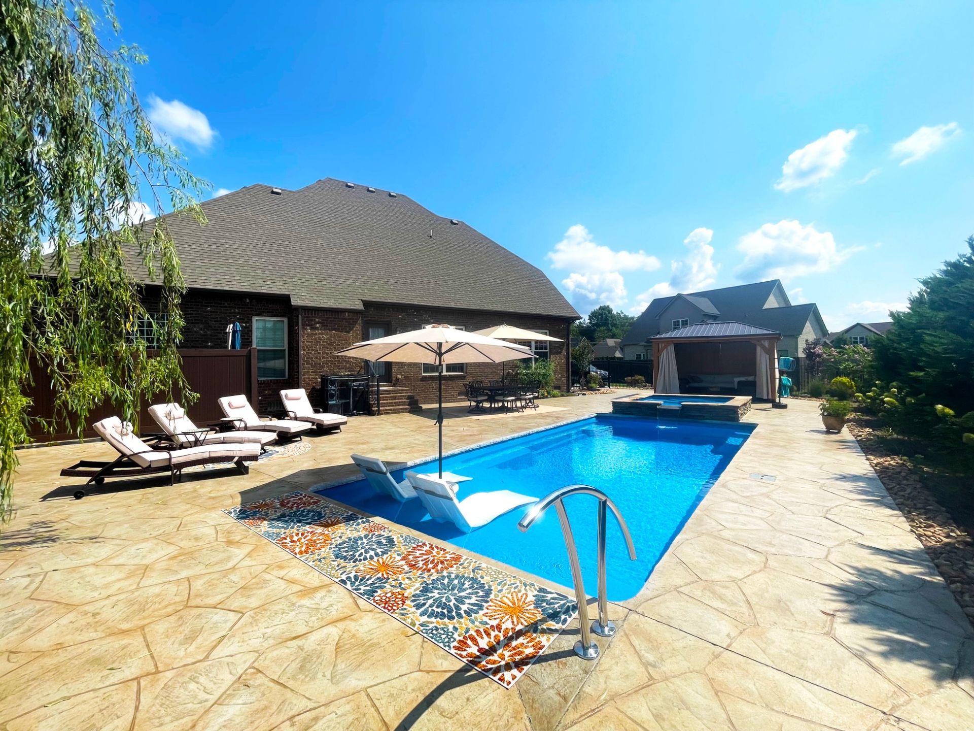 Backyard poolside view of Aspen 14x30 with spa, lounge area, and shaded seating in Murfreesboro TN