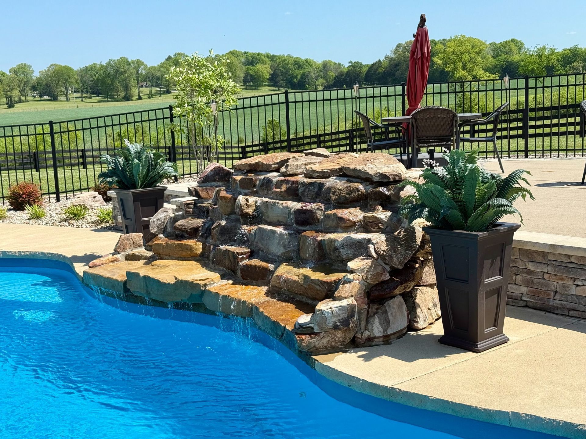 Close-up of stacked stone waterfall cascading into pool at Lascassas home