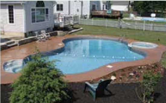 A large swimming pool is in the backyard of a house