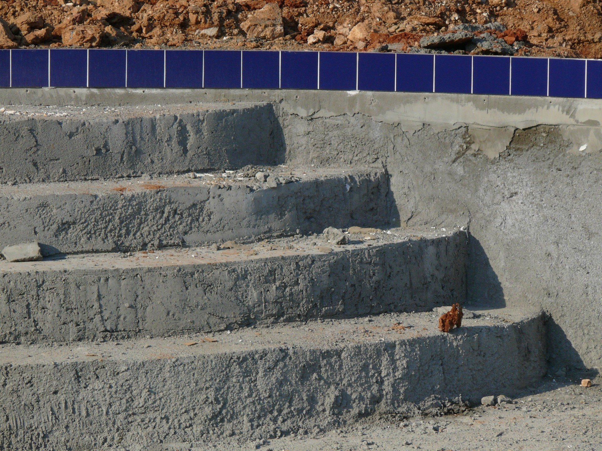 A concrete staircase with blue tiles on the side